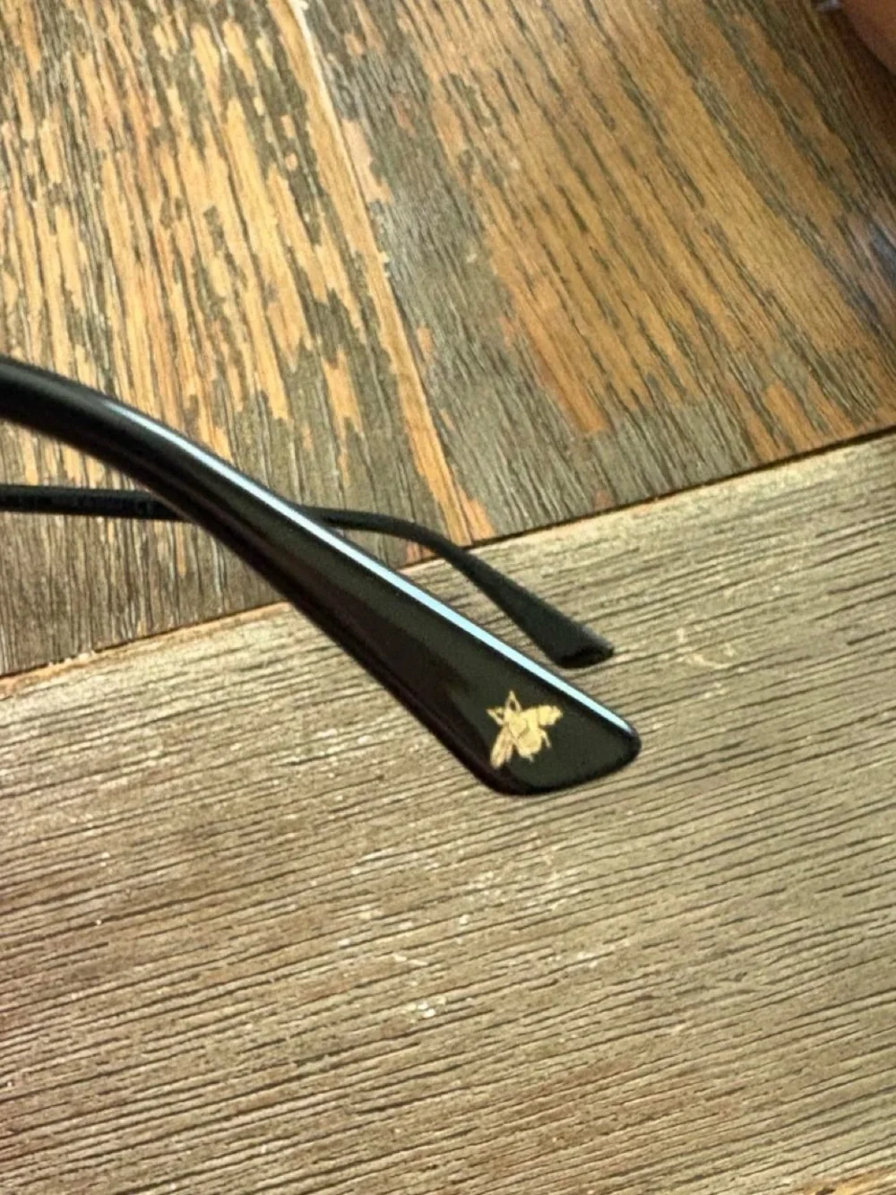 Gucci GG0026O eyeglasses in black with gold logo accents on the temples